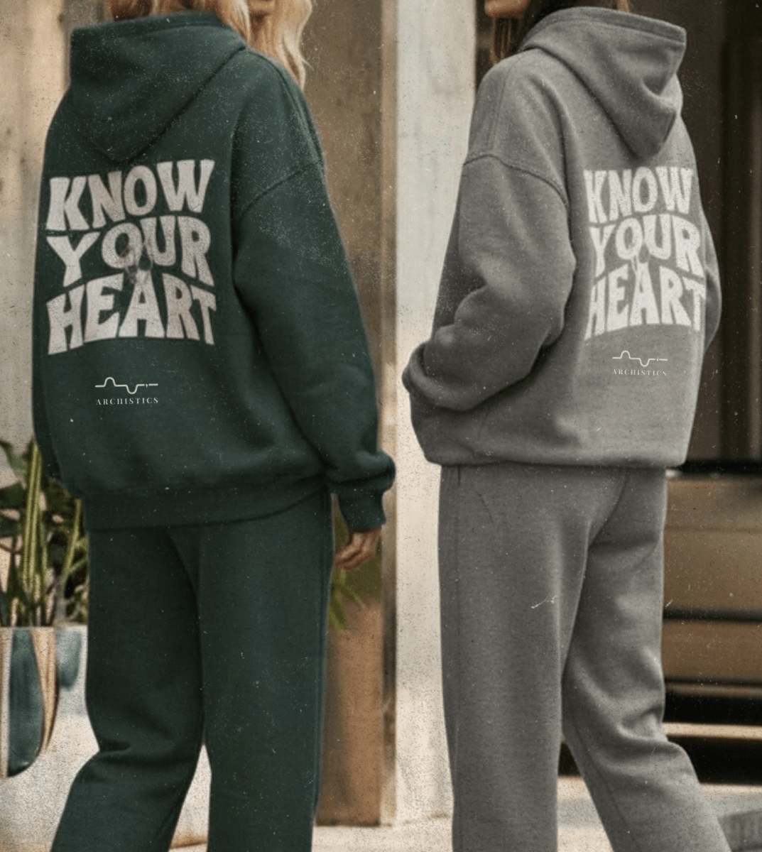 Person wearing a brown hoodie with 'Know Your Heart' text, standing in an urban setting.