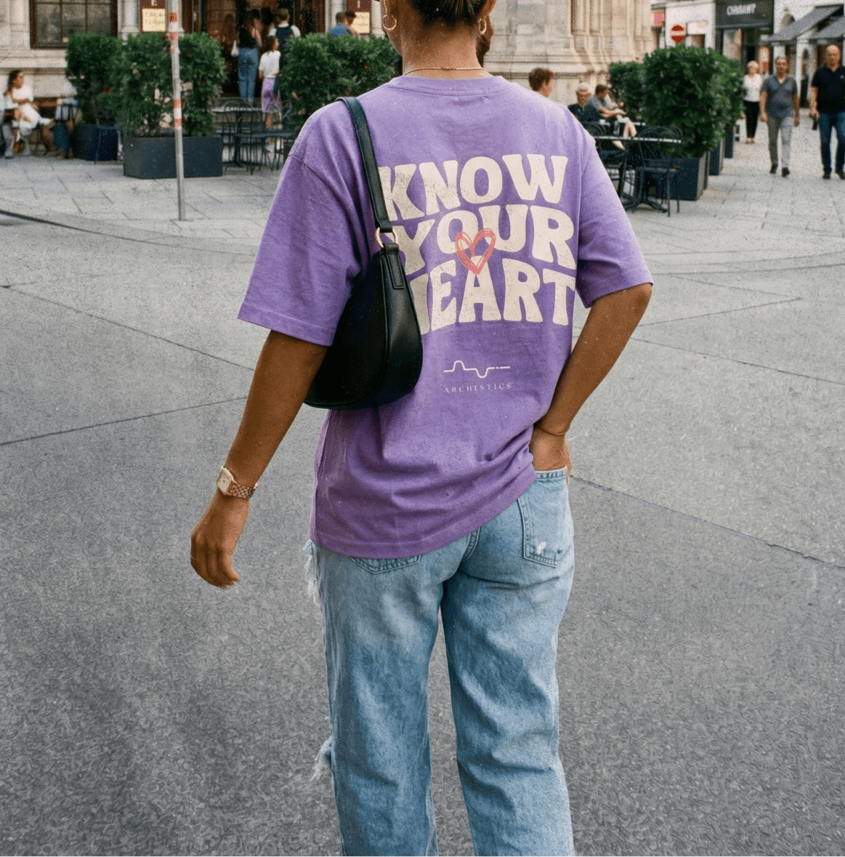Person wearing a purple t-shirt with text on a city street