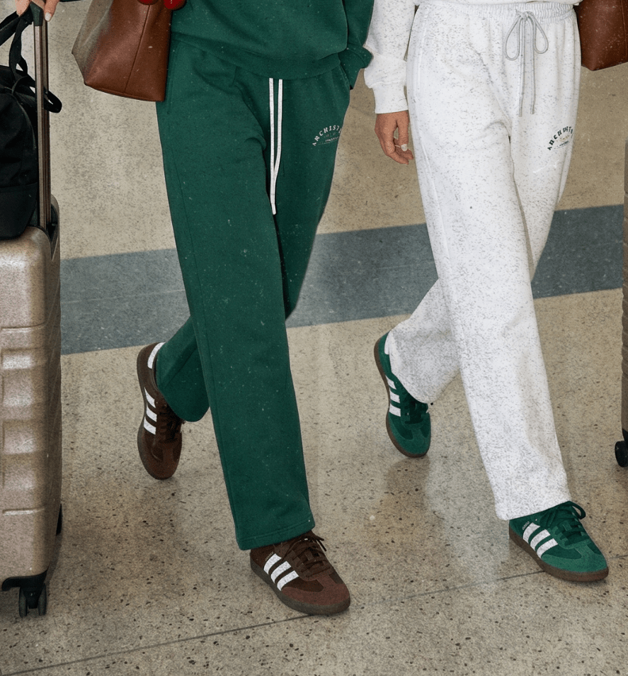 Two women walking through an airport with luggage
